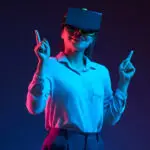 Frau mit Virtual-Reality-Brille zeigt nach oben in blau-rotem Licht